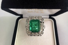 Anello in Oro Bianco con Smeraldo rettangolare, con contorno di Diamanti taglio brillante